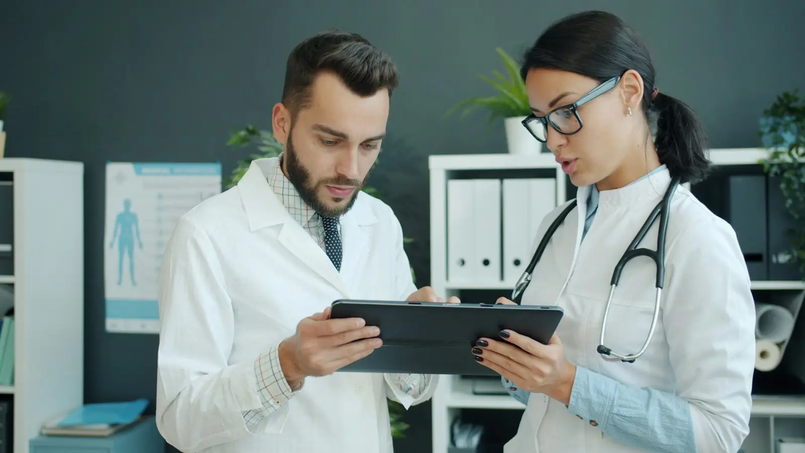 Two doctors reviewing a case together on a tablet